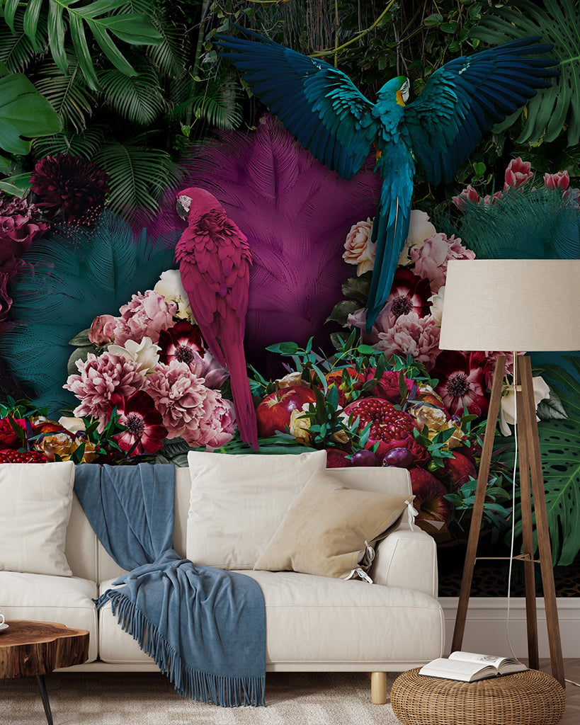 Living Room - A vividly colored living room with a Parrot Paradise Wallpaper Mural from Decor2Go Wallpaper Mural, featuring lush green foliage and vibrant flowers. Two majestic parrots are depicted mid-flight against the mural, overlooking a modern white sofa.