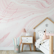 Bedroom - A cozy children's bedroom corner with a Decor2Go Wallpaper Mural pink marble wallpaper, a small wooden bed shaped like a house with star decor, a white nightstand, a pink lamp, and a container with colorful rolled papers.