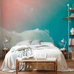 A serene bedroom with a large bed covered in light gray linens, a book open on a wooden bench at the foot of the bed, against a vibrant Decor2Go Wallpaper Mural transitioning from blue to
