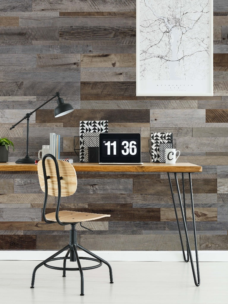 A modern home office setup with a minimalist wooden desk, metal chair, and stylish wall map art above. The wall is accented with Decor2Go Wallpaper Mural, adding a rustic touch to the decor.
