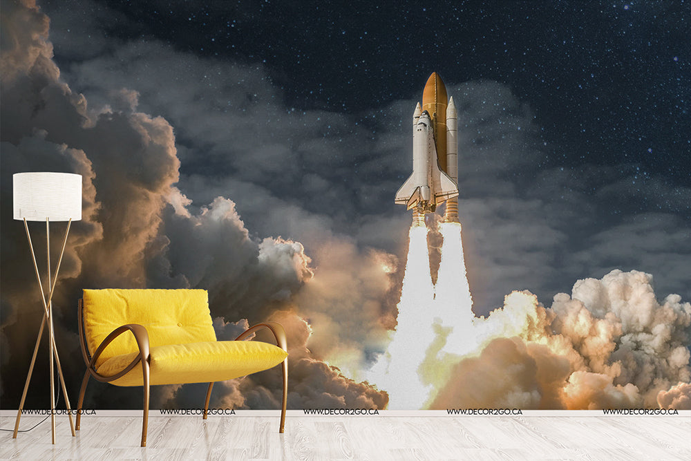 A stylized room with a vibrant yellow armchair and floor lamp, featuring a Decor2Go Wallpaper Mural of a Rocket to the Moon launching into a cloud-filled sky.