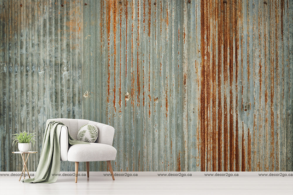A modern white armchair with a green blanket and a small plant on a side table, set against a large textured wall featuring Decor2Go Wallpaper Mural.