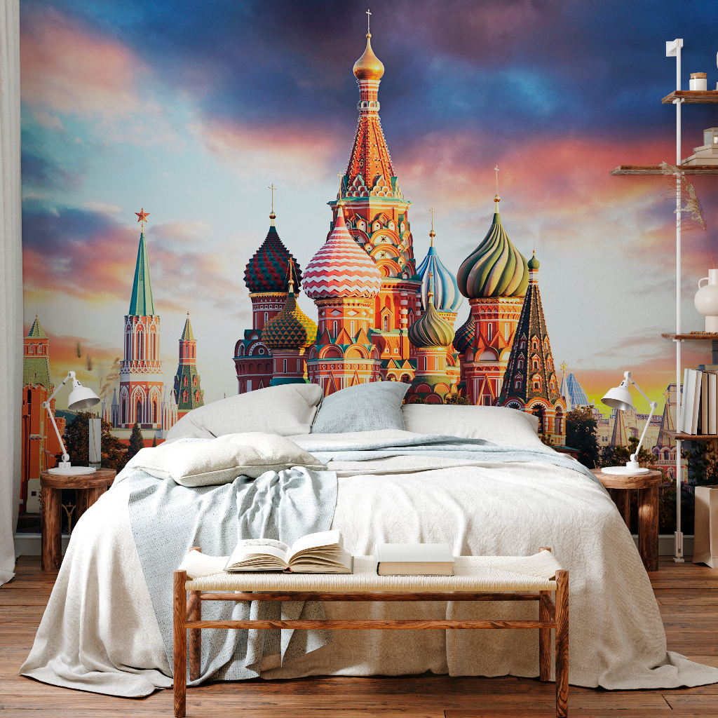 A cozy bedroom with natural wood floors and a large bed covered with a beige comforter. A vibrant, custom-sized Decor2Go Wallpaper Mural of St. Basil's Cathedral in Moscow dominates the room, adding a colorful