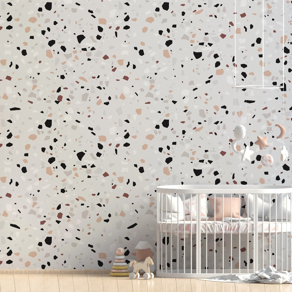 A modern nursery featuring a white crib flanked by stuffed animals and wooden toys, set against a luxurious Decor2Go Wallpaper Mural in neutral tones. Bright natural light enhances the calm, minimalist interior design.