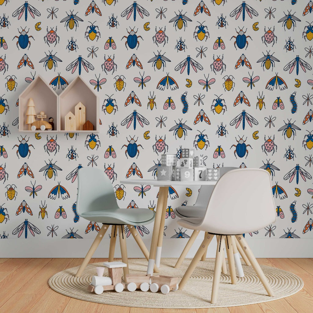 A children's playroom with a contemporary Decor2Go Wallpaper Mural featuring The Beetles, a small wooden table with chairs, a toy house, and various alphabet blocks scattered on a circular rug.