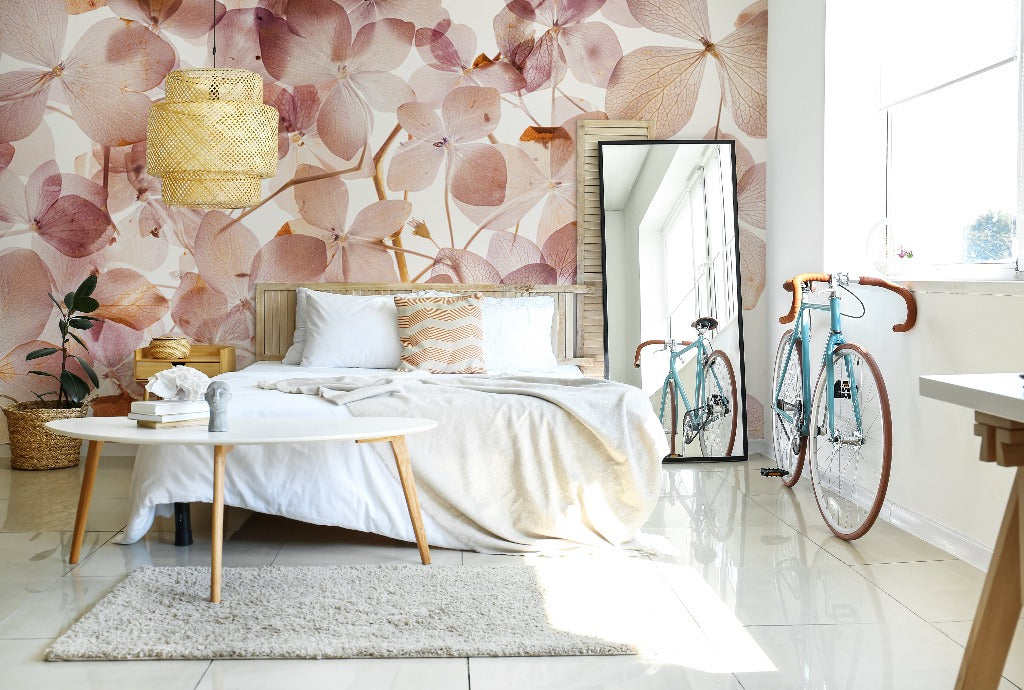 Bright bedroom with a large bed, white linens, and a Translucid Flowers Wallpaper Mural by Decor2Go Wallpaper Mural. A bicycle is parked beside a full-length mirror. Sunlight floods in through a large window.