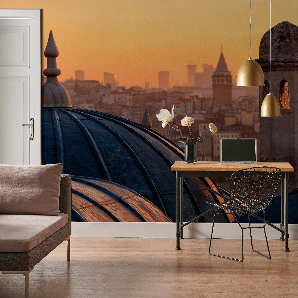 A modern home office space with a large window overlooking a cityscape at sunset. The room features a sleek desk, a laptop, a comfortable chair, and stylish lighting with Decor2Go Wallpaper Mural.