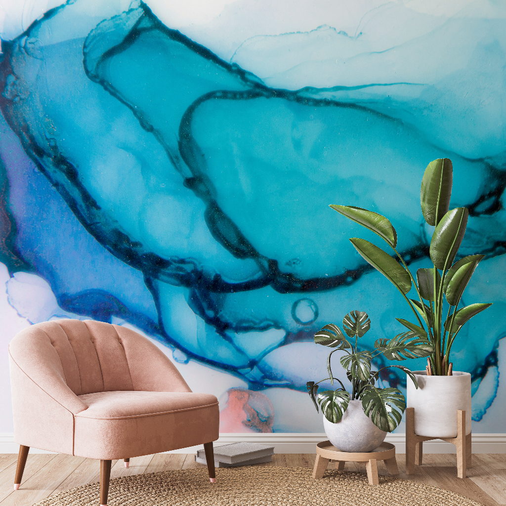 A modern artist's space featuring a blush pink armchair and two potted plants beside a Decor2Go Wallpaper Mural in Turquoise Ink.
