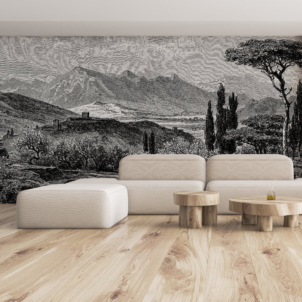 Living Room - A contemporary living room with light wood flooring showcases a minimalist beige sofa paired with three wooden coffee tables. The wall is adorned with the "Tuscan Serenity Wallpaper Mural" by Decor2Go, featuring an intricate black-and-white depiction of the Tuscan countryside, complete with mountains, trees, and a rural scene.