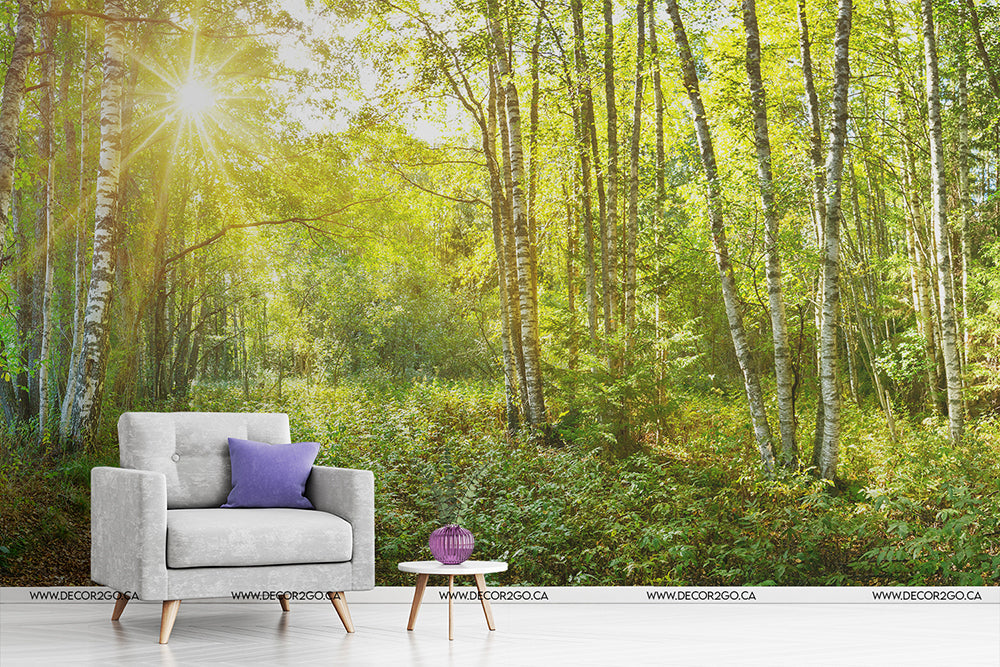 A modern gray armchair with a purple cushion and a small wooden table with a decorative item, set in a digitally created serene forest under bright sunlight, featuring Decor2Go Wallpaper Mural.
