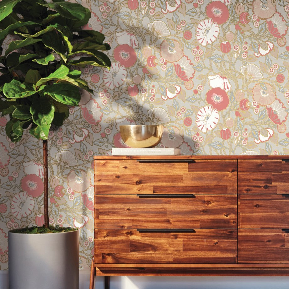 grey pink floral wallpaper on the wall, wooden dresser in front of the wall and big green plant