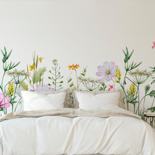 A minimalist bedroom featuring a bed with white linens against a large Decor2Go Wallpaper Mural with vivid, life-sized flowers and greenery on the walls.