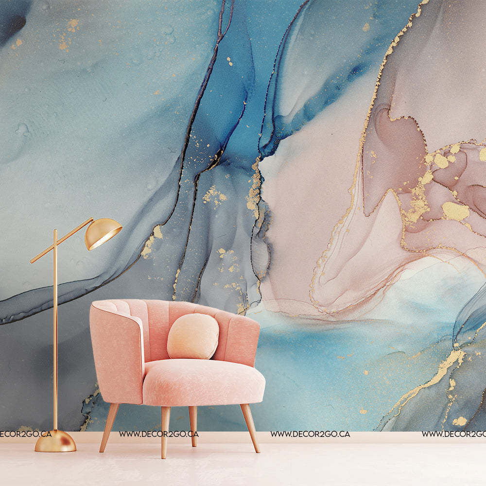 A modern interior featuring a pink armchair and a copper floor lamp against an artistic wall with a Decor2Go Wallpaper Mural in blue and pink marbled patterns accented with gold.