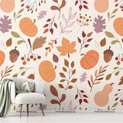 Kids Room - A cozy room corner with a stylish armchair and throw blanket near a decorated wall featuring a vibrant kids room Decor2Go Wallpaper Mural with leaves, branches, and pumpkins. A small plant stand with greenery is visible.