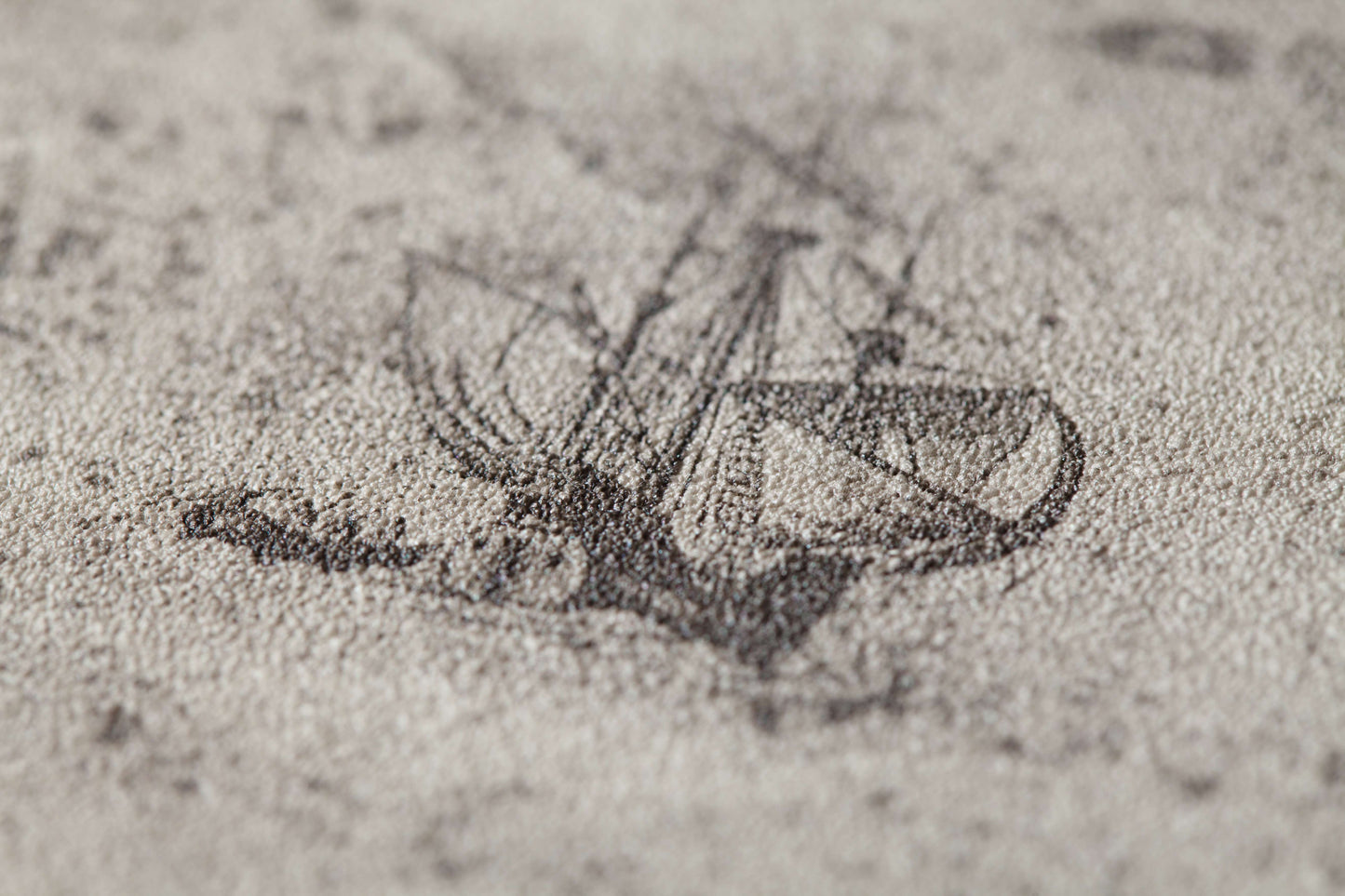 A faded, vintage-style sketch of a sailing ship with tall masts and billowing sails on a textured, sepia-toned background. The scene pattern appears detailed yet weathered, contributing to the aged and historical aesthetic of the artwork. This describes the Voyage Wallpaper (114 SqFt) by Palitra.