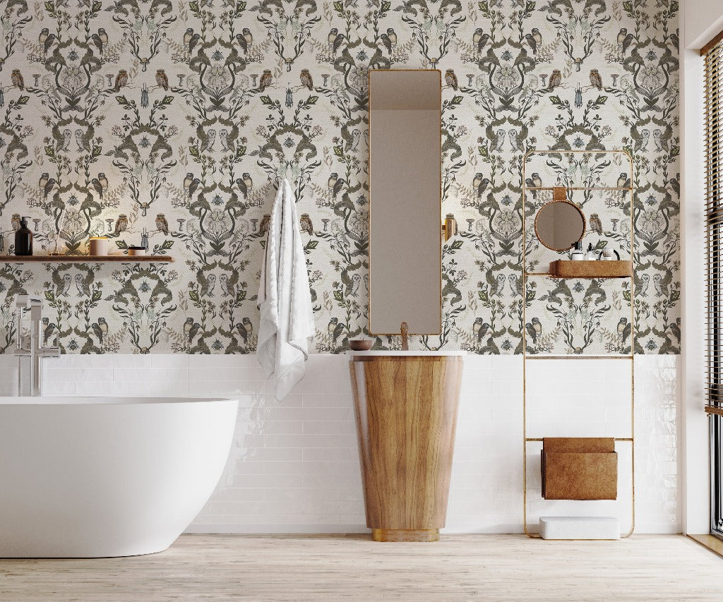 A stylish bathroom featuring a freestanding tub, a unique wooden sink, and a wall adorned with Decor2Go Wallpaper Mural's Vintage Owls Garden Wallpaper Mural. A tall mirror and a small circular mirror enhance the decor.