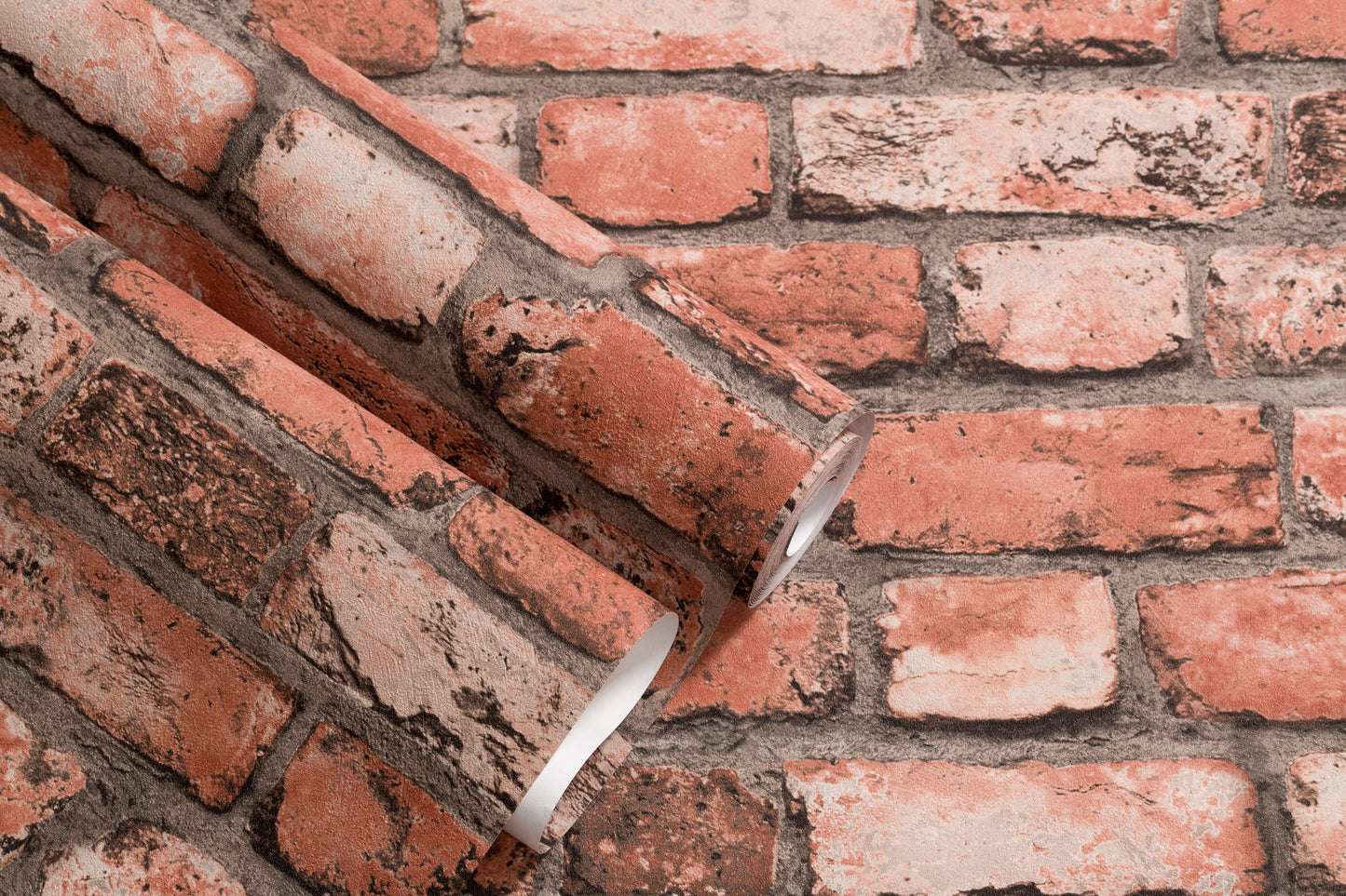 Two rolls of Palitra's Brick Wall Wallpaper (114 SqFt) are pictured against a backdrop of the same design. The wallpaper, crafted using hot stamping techniques on non-woven material, features a realistic red and brown brick look, creating an illusion of an actual brick wall.