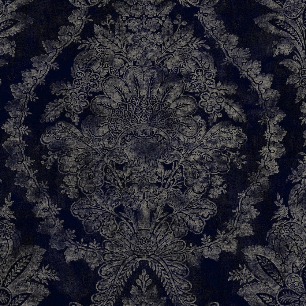 An ornate, dark blue fabric with pearlescent floral motifs and an intricate silver pattern. The design features large, detailed flowers and leaves, creating an elegant, symmetrical motif. The Classic Charleston Damask Wallpaper in Blue (60 SqFt) by York Wallcoverings has a reflective quality that enhances the richness of the pattern.